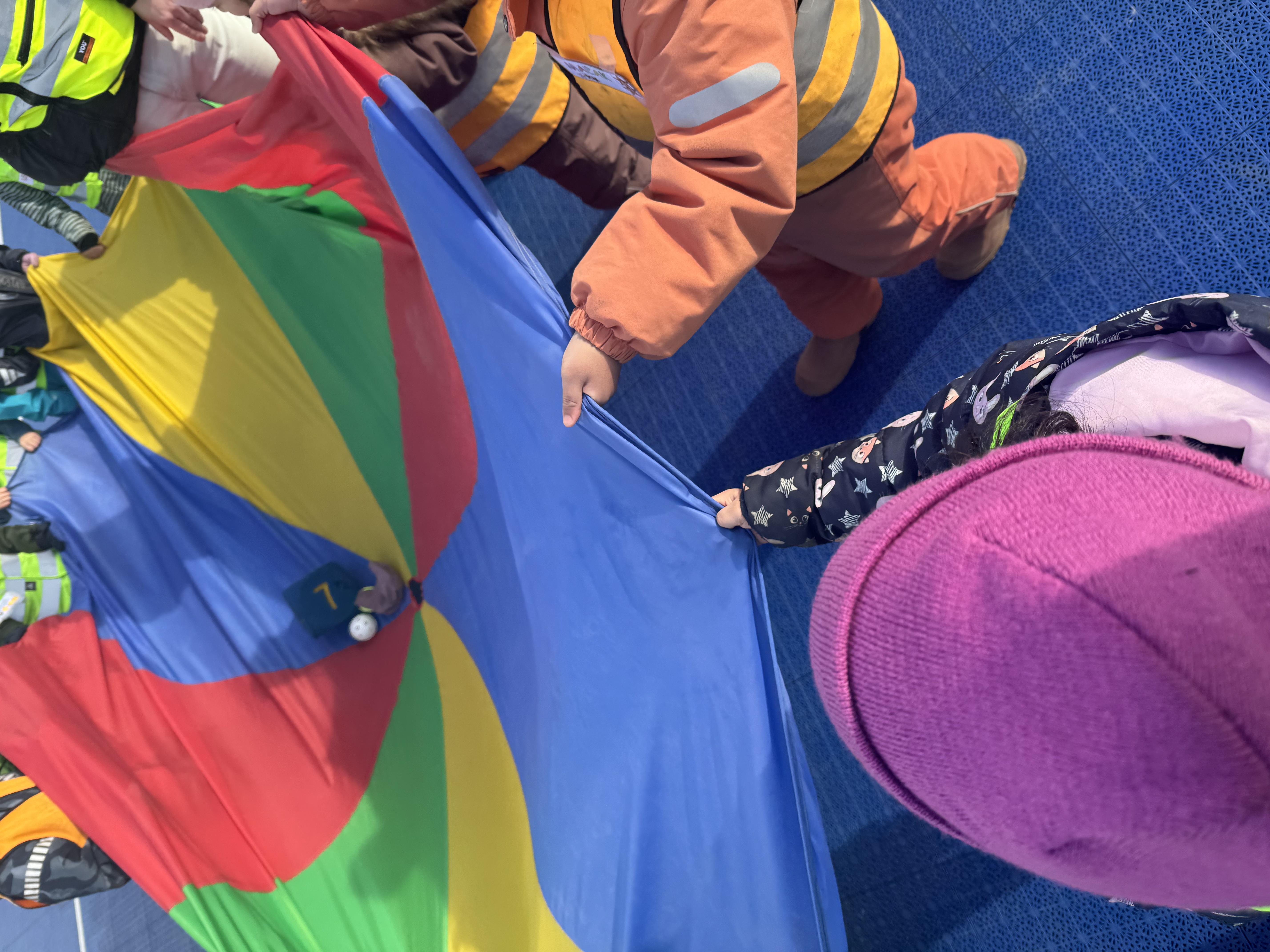 en person i en oransje jumpsuit som holder en fargerik paraply