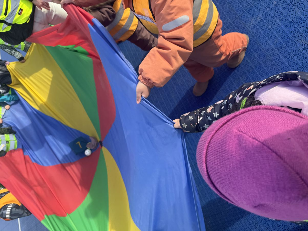 en person i en oransje jumpsuit som holder en fargerik paraply