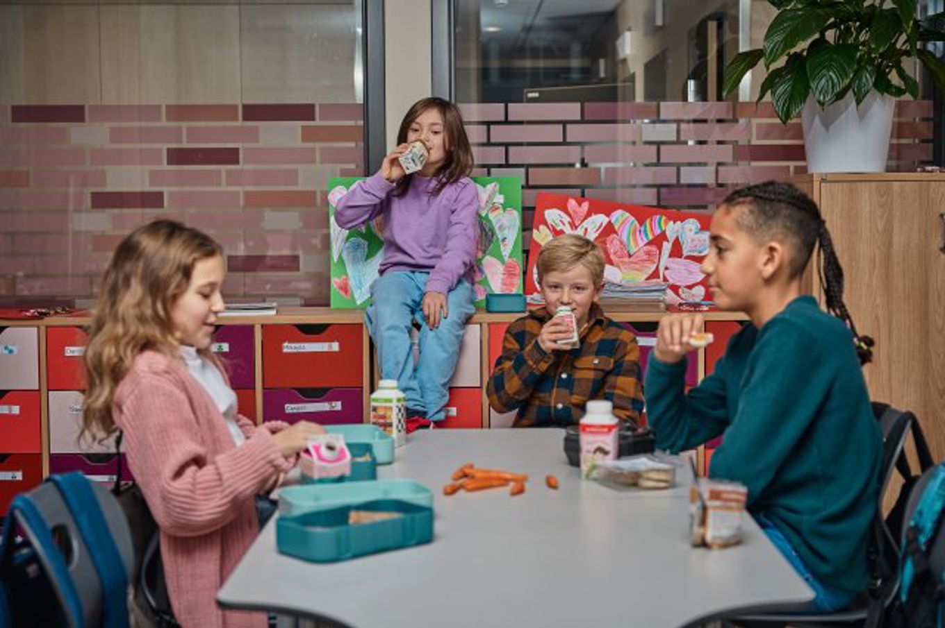 en gruppe mennesker som sitter rundt et bord og spiser mat