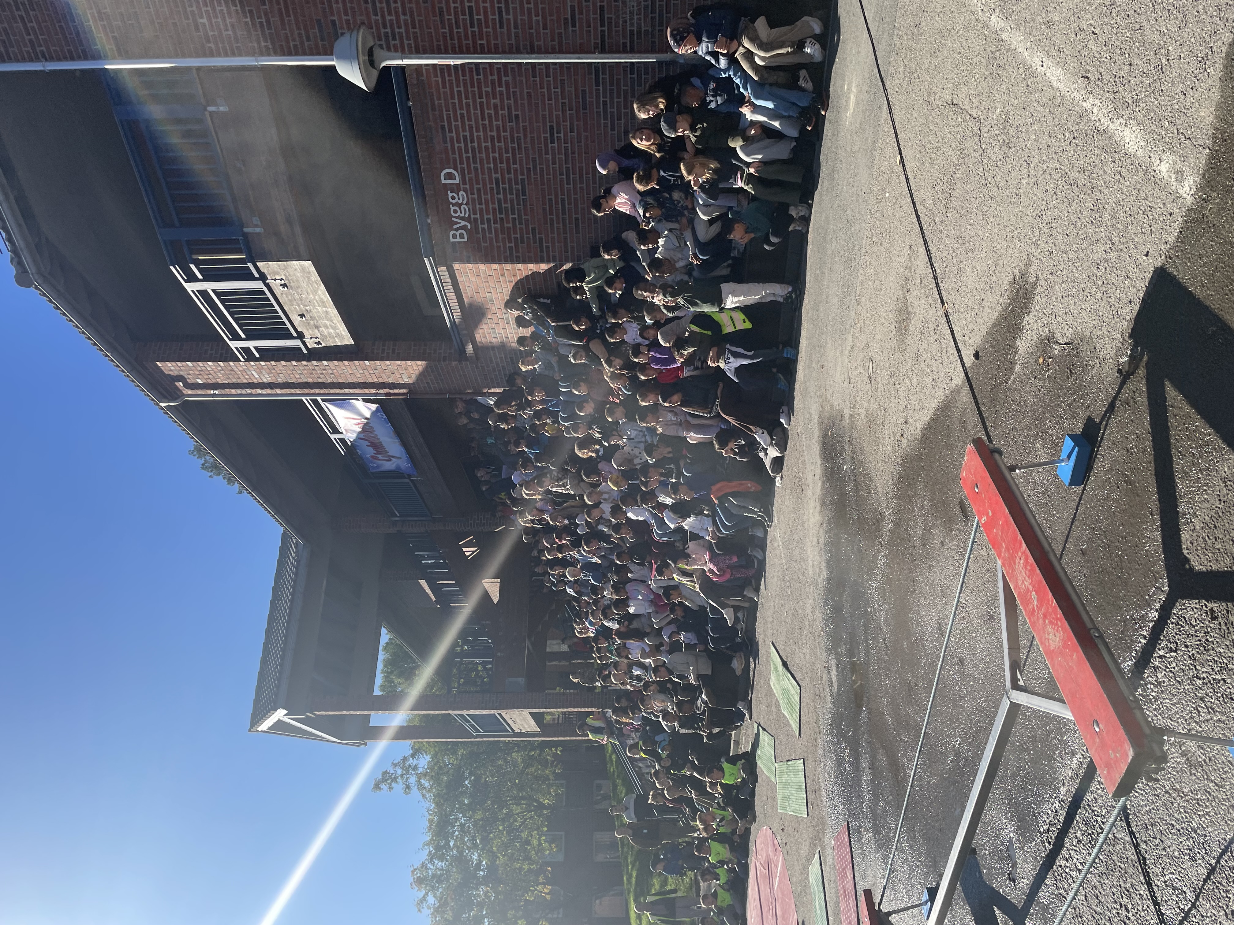 en gruppe mennesker som står på et fortau ved siden av en vannmasse