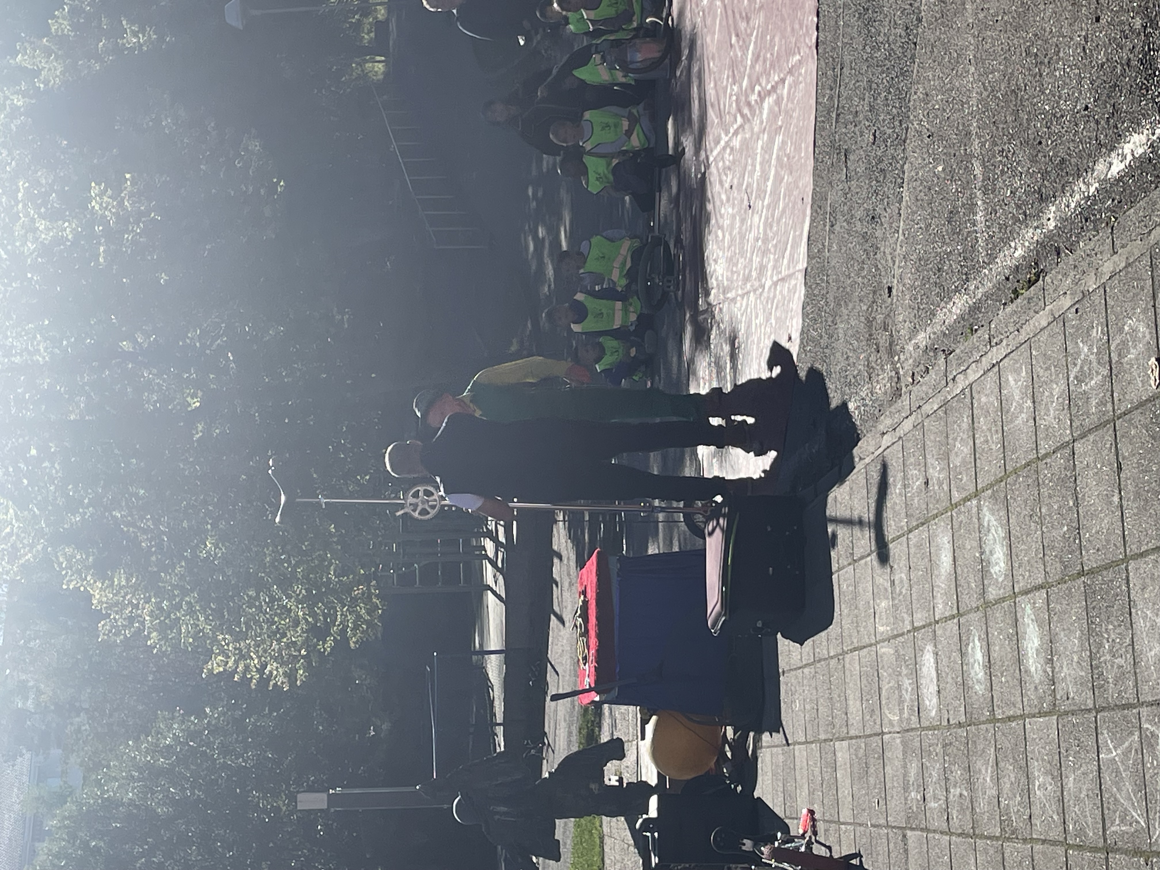 en gruppe mennesker som står på en gate med en brann i bakgrunnen