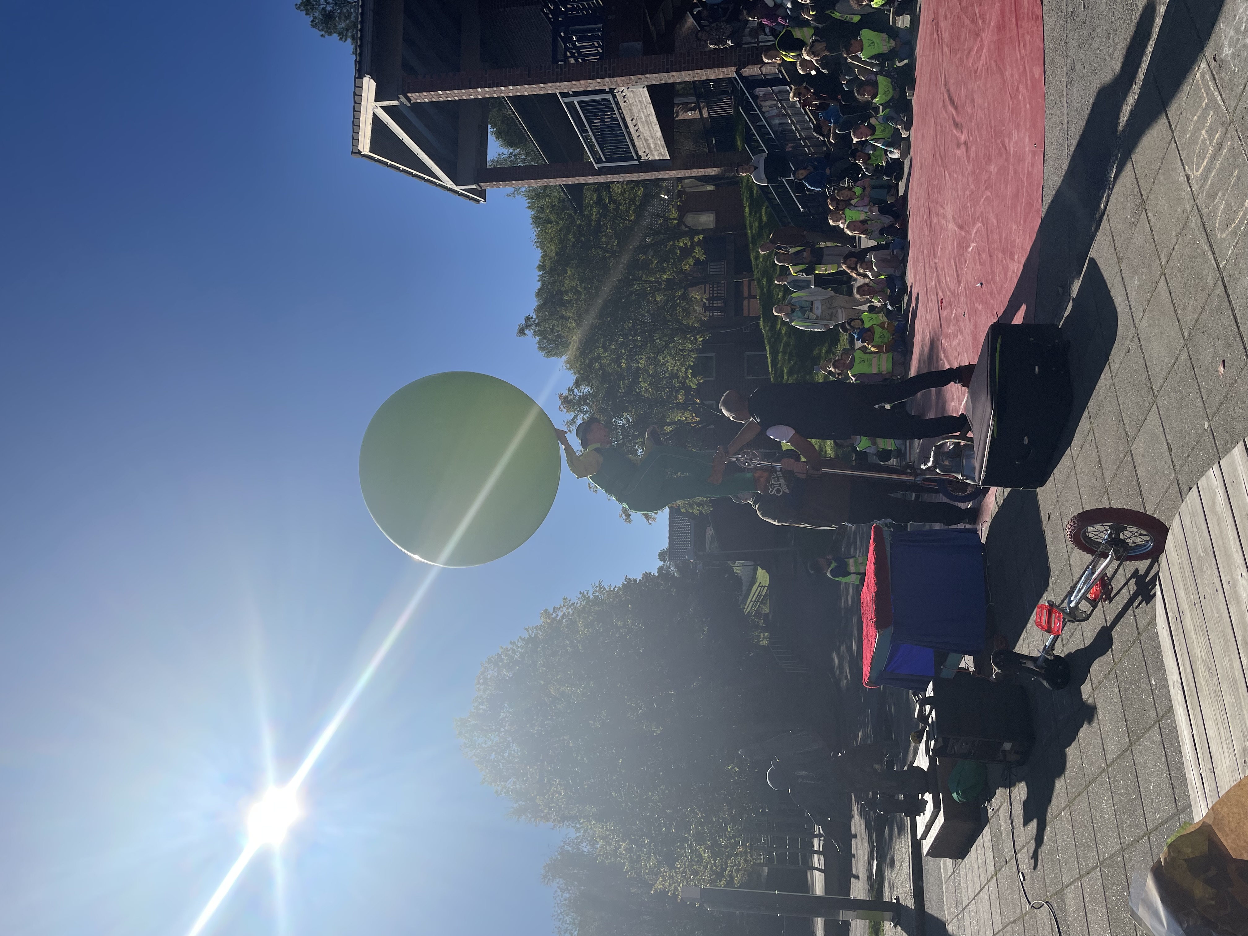 En gruppe mennesker på en scene med en stor grønn ballong i luften