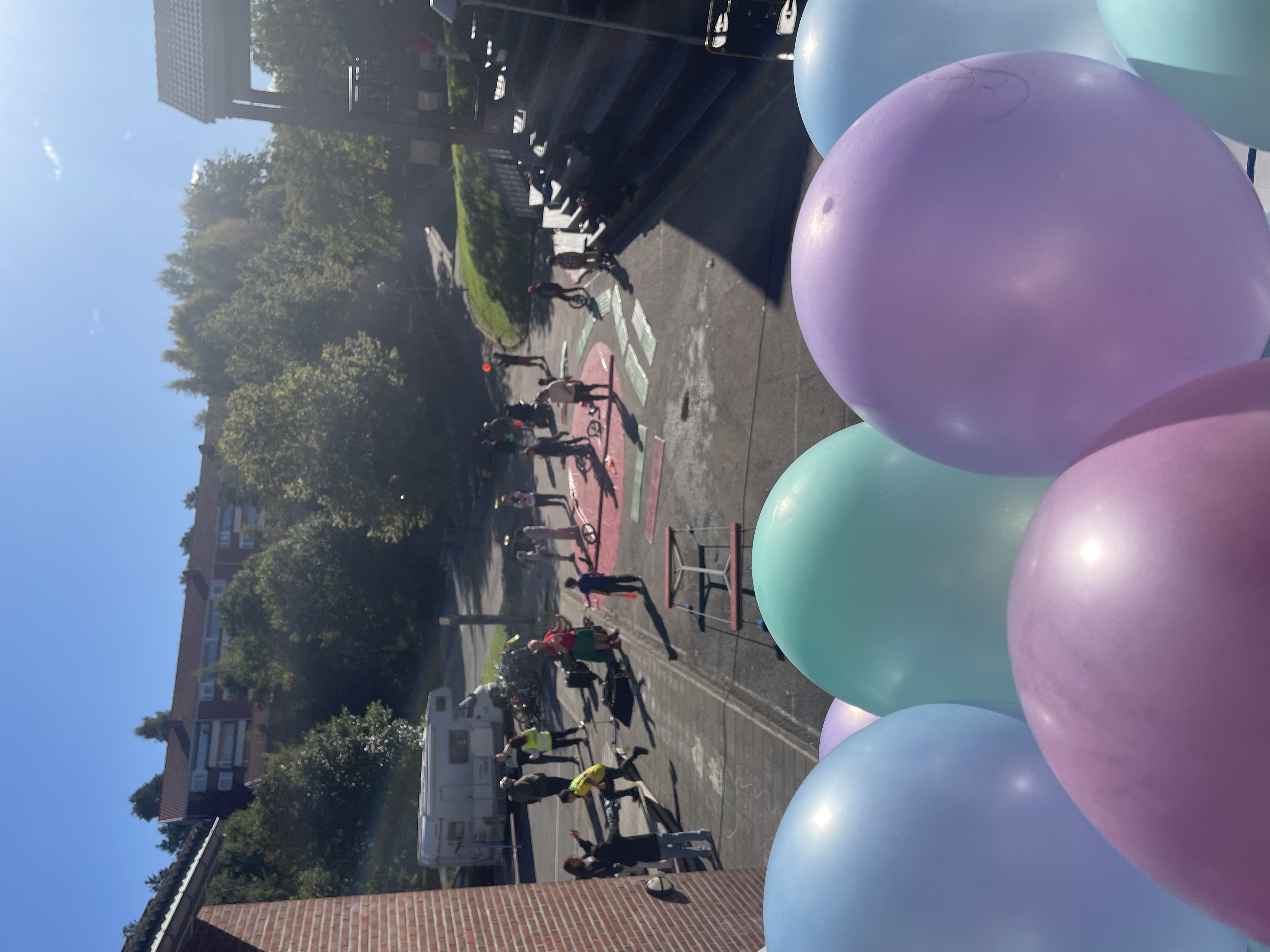 en gruppe mennesker på en gårdsplass med ballonger