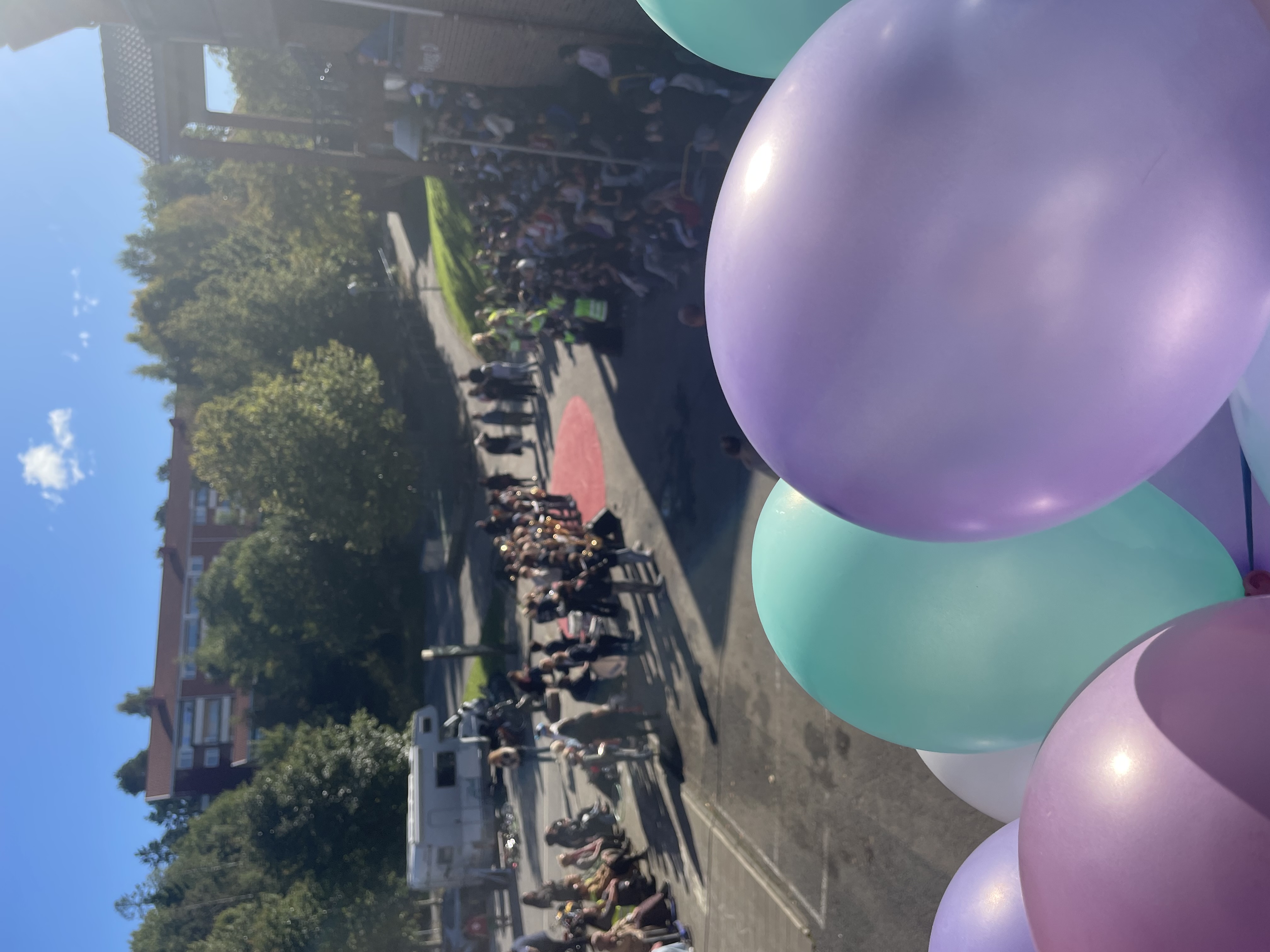en gruppe mennesker som står på en gate med ballonger