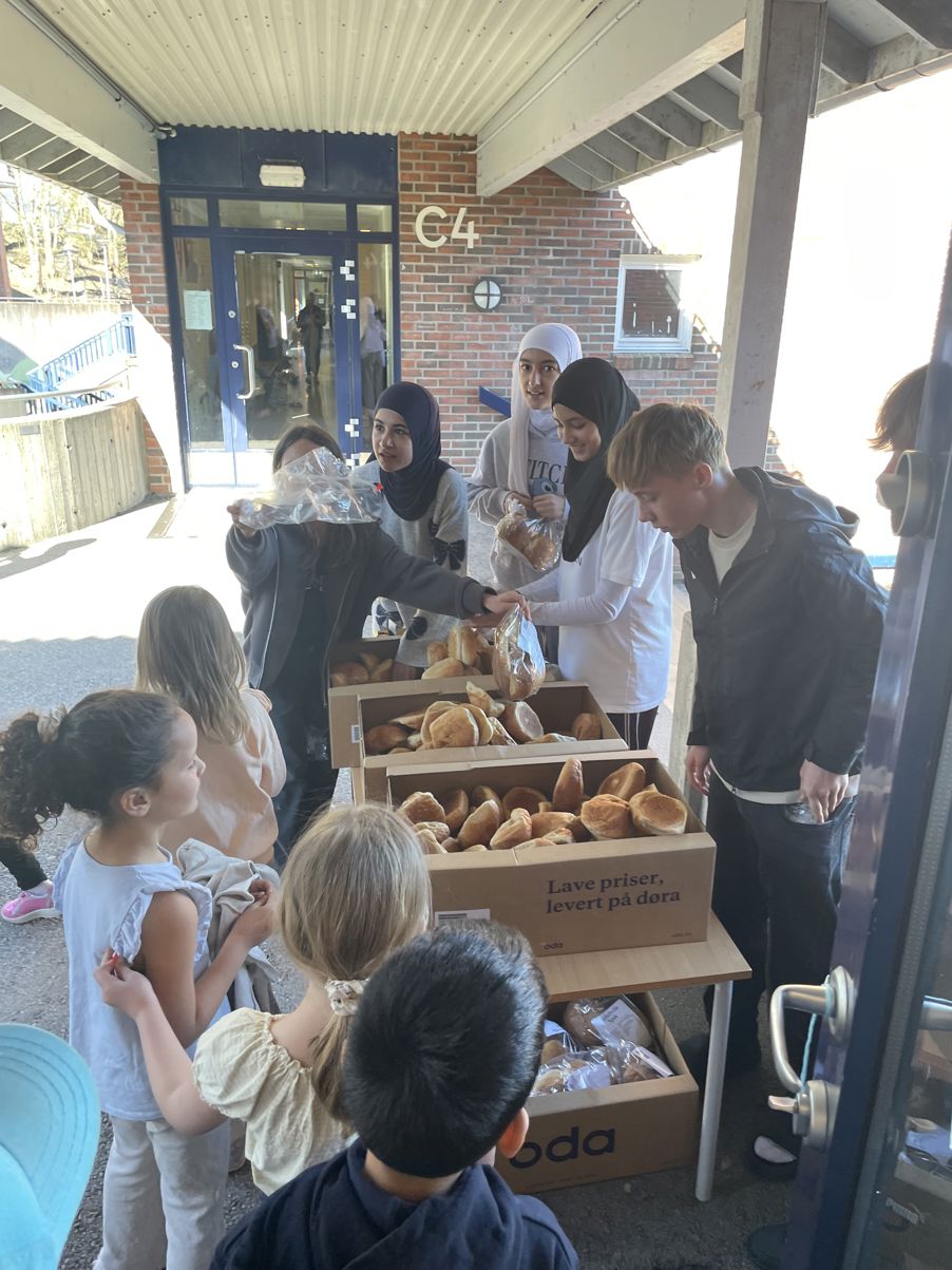 En gruppe mennesker står rundt en eske med donuts