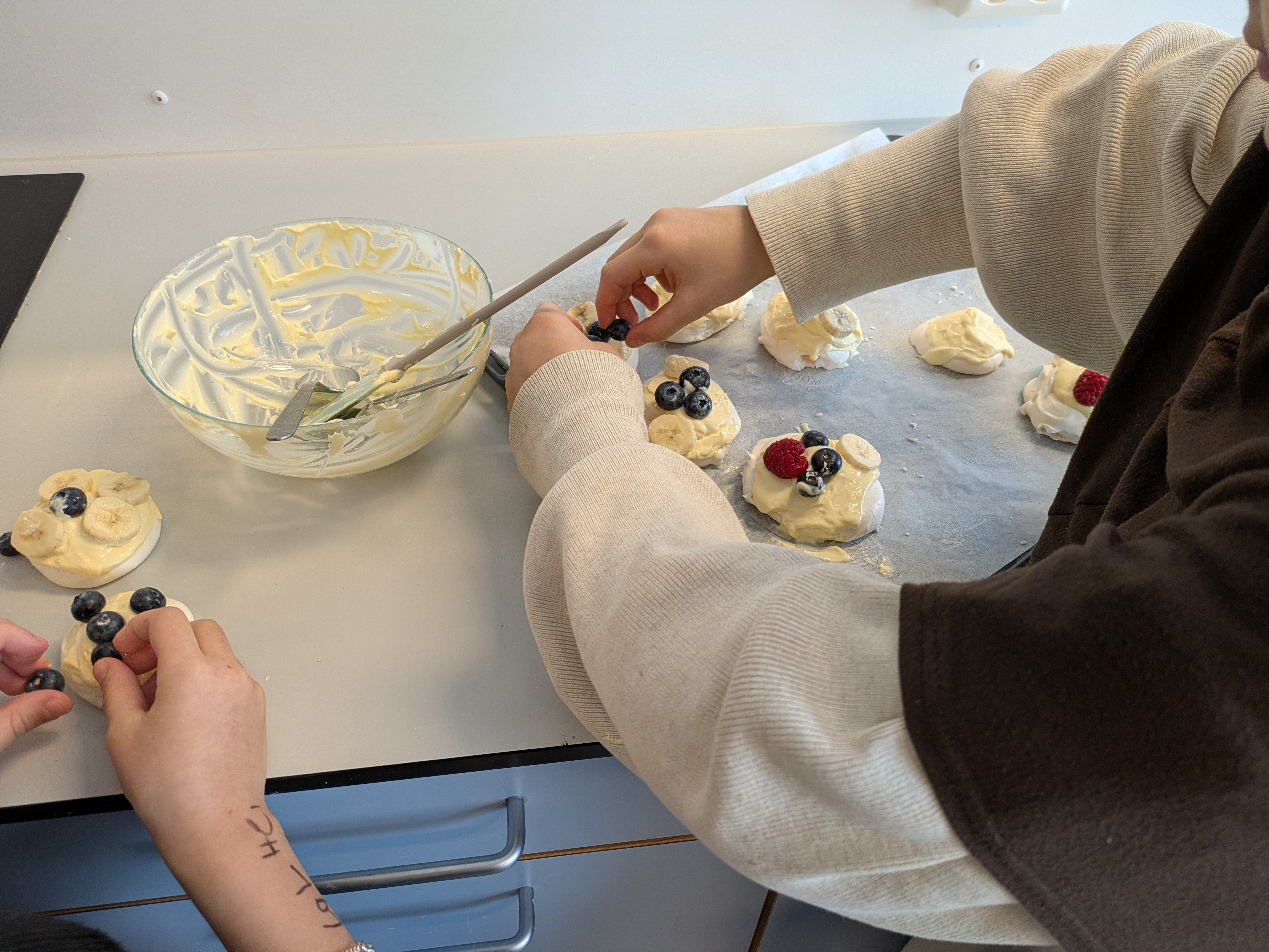 En gruppe mennesker som lager cupcakes