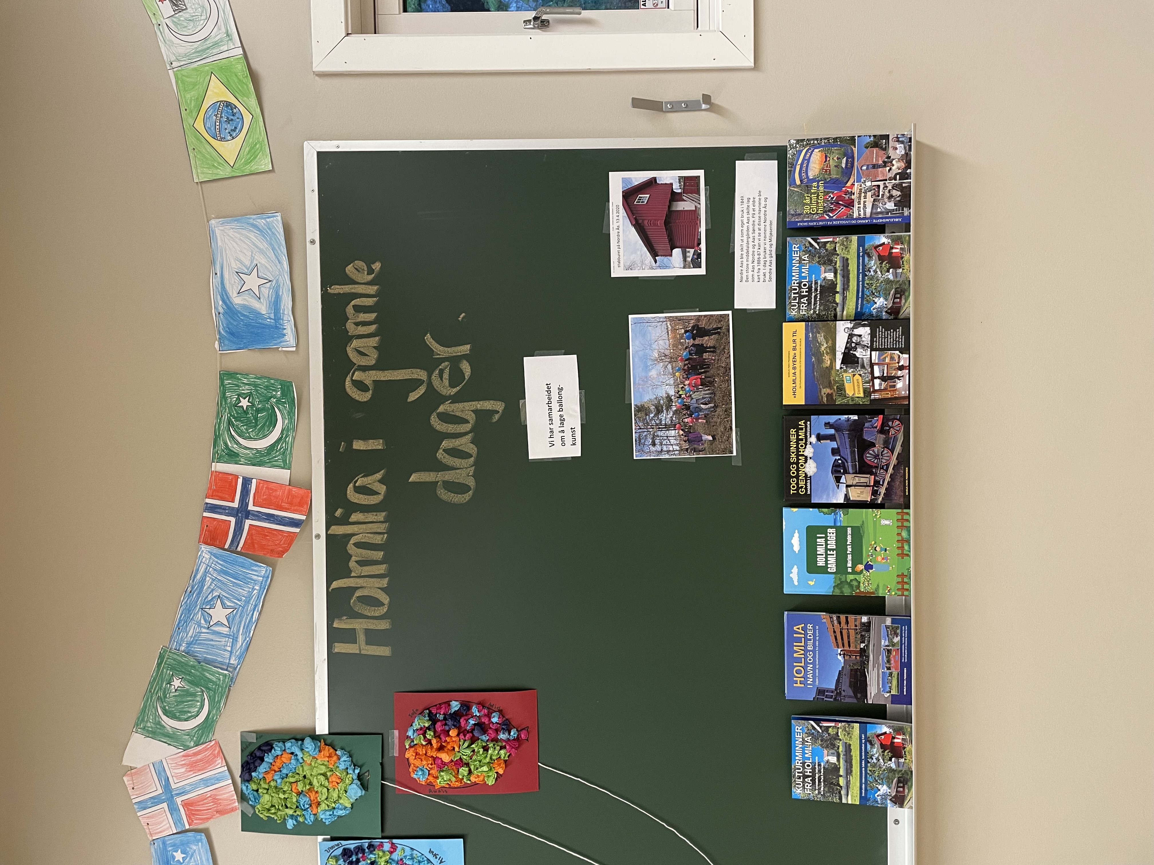 En grønn tavle med bilder og flagg på